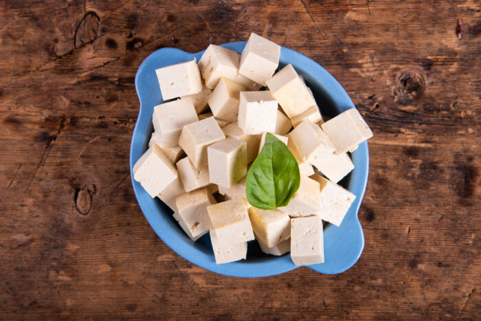 Crispy golden tofu cubes frying in a pan for salad