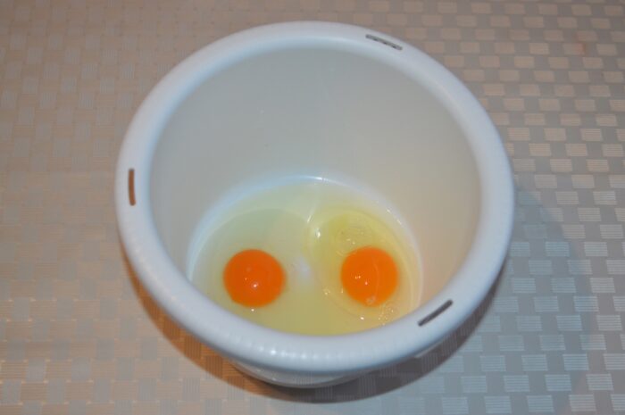 Cracked eggs in a large mixing bowl ready for mixing