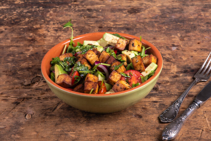 Crispy tofu and avocado salad assembled in a bowl ready to serve