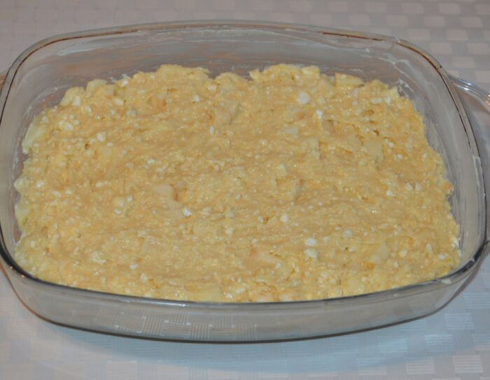 Cake batter spread evenly in a greased baking pan