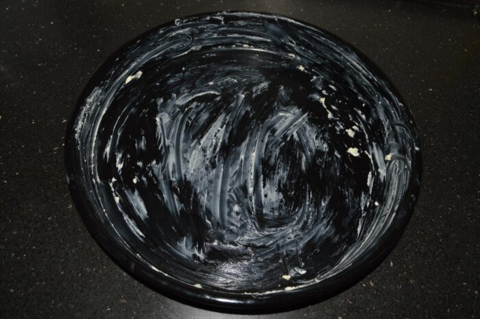 Thick baking dish coated with a generous layer of softened butter