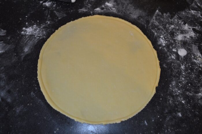 Thin cake layer baking in the oven with extra dough for a seventh layer