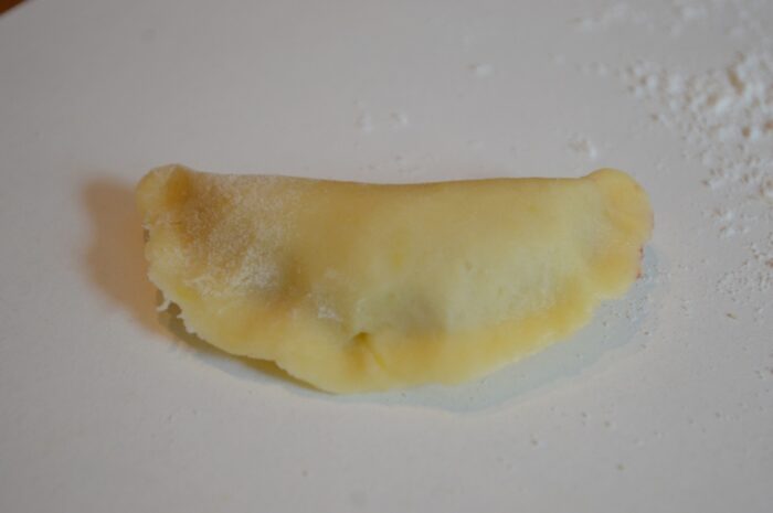 Small crescent-shaped cookies formed by folding dough around the filling