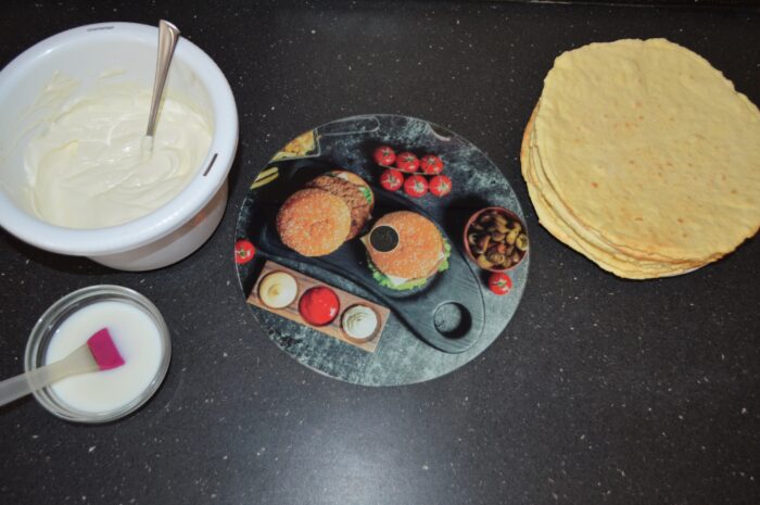 Work surface prepared with cake layers, cream, and tools for assembly