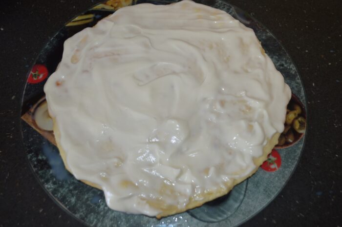 Sour cream filling spread evenly over a cake layer