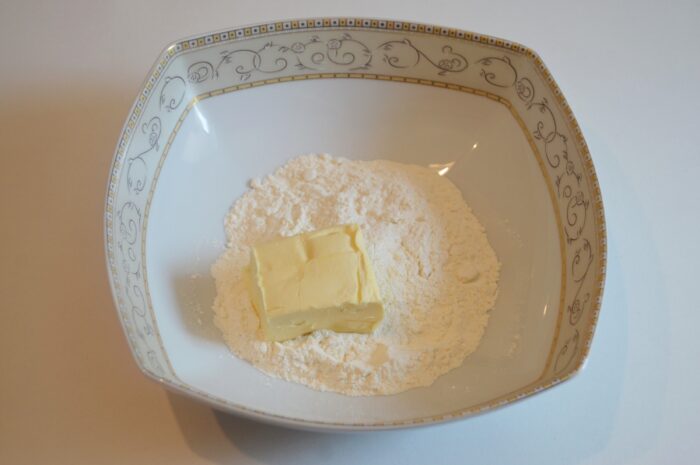 Flour and softened butter combined in a mixing bowl