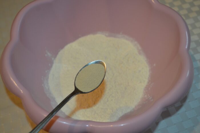 Dry yeast sprinkled over flour in the bowl