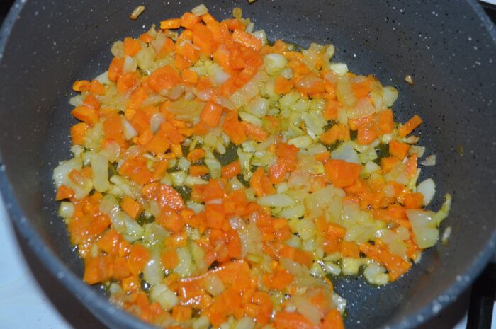 Onion, carrot and garlic gently sautéing in a pot
