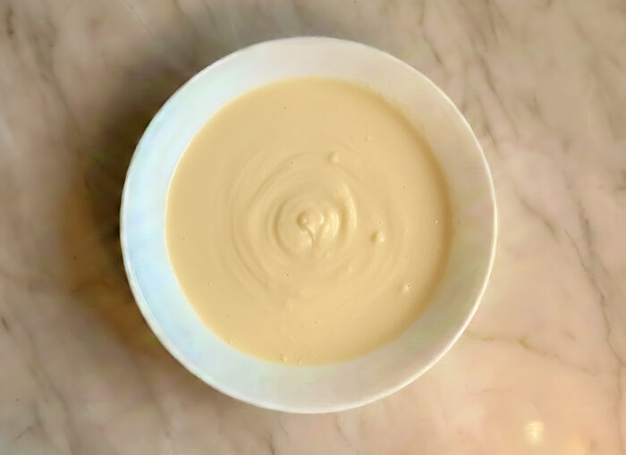 Smooth dough batter being whisked in a mixing bowl