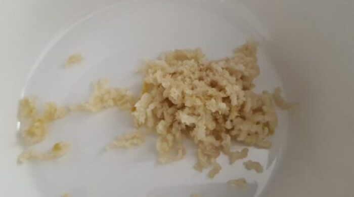 Minced garlic cloves on a cutting board beside a knife