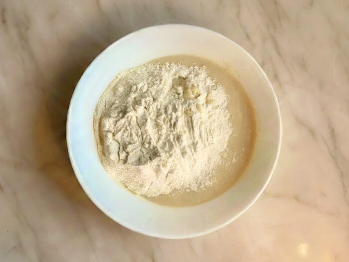 Remaining flour being added on top of the dough mixture