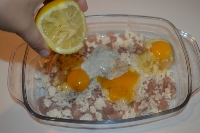 Fresh lemon being squeezed over the chicken