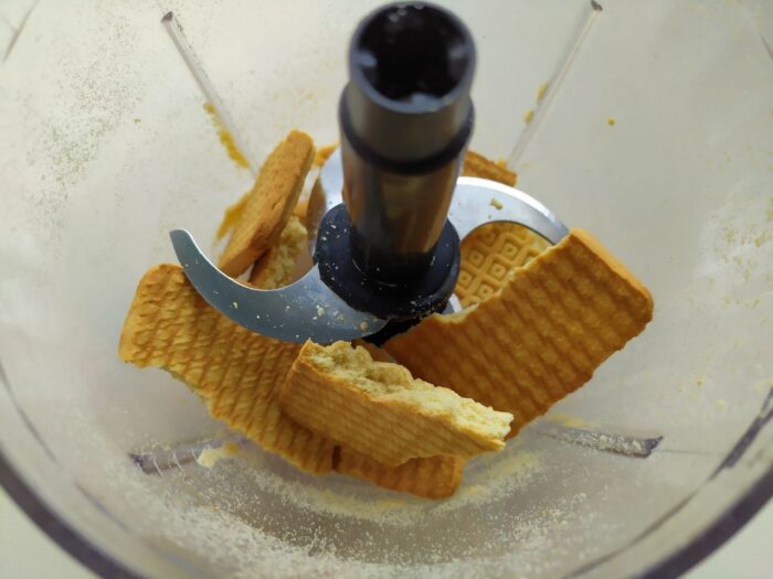 Broken biscuits in a bowl ready to be mixed for chocolate salami