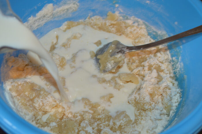 Whisking milk into the batter until the texture becomes smooth and lump‑free