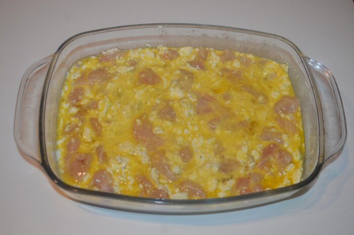 Mixed chicken and cheese casserole placed in the oven