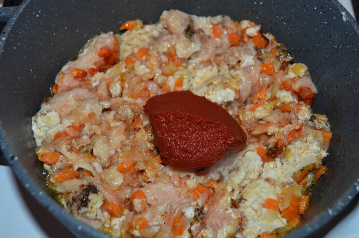 Tomato paste stirred into the meat mixture until evenly coated
