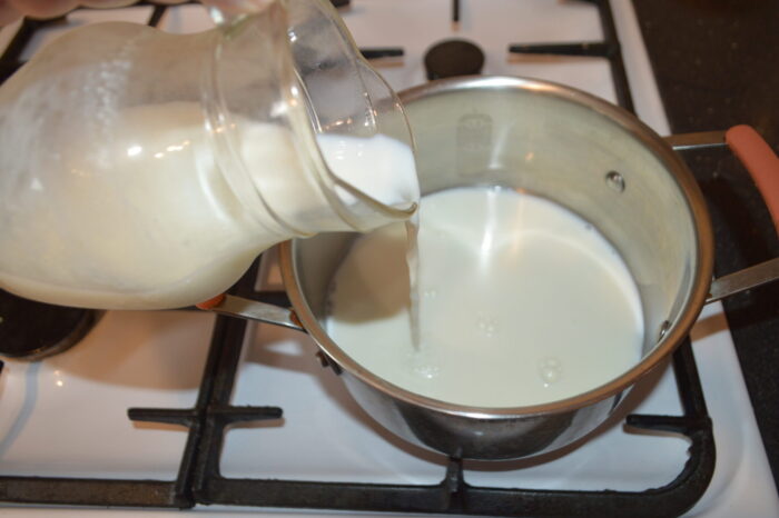 Leche calentándose en una cazuela sobre el fuego