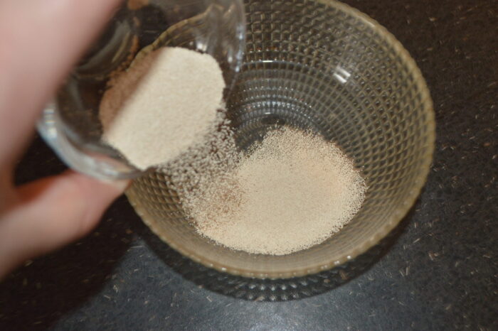 Levadura seca disolviéndose en un vaso con agua tibia