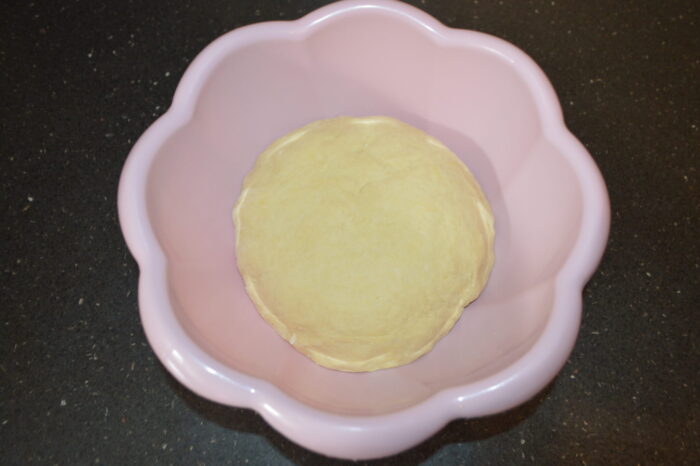 Bol con la masa cubierta por un paño de cocina