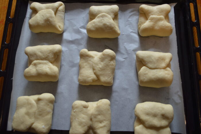 Empanadillas moldeadas reposando sobre una bandeja con papel de horno