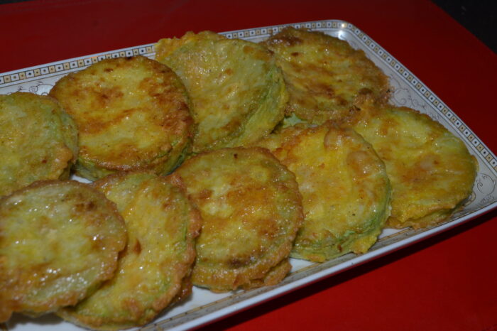 Plato de calabacines empanados, dorados y crujientes, listos para servir